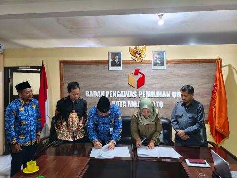 Ketua dan Anggota Bawaslu Kota Mojokerto serta Kepala Cabang Dinas Pendidikan Wilayah Kabupaten dan Kota Mojokerto sedang melakukan MoU.